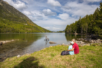 Fototapeta na wymiar Beautiful Pyrenees mountain landscape, nice lake with tourist couple from Spain, Catalonia.