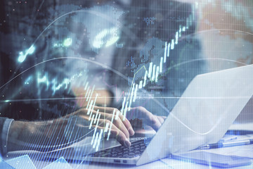 Double exposure of market chart with man working on computer on background. Concept of financial analysis.