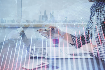 Multi exposure of stock market chart with man working on computer on background. Concept of...