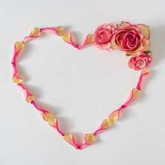 Creative layout made with rose petals and pink flowers. Minimal nature love background. Spring flowers concept.