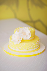 Obraz na płótnie Canvas Yellow sweet lemon cake decorated with white flowers