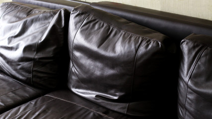 Brown leather sofa with pillows