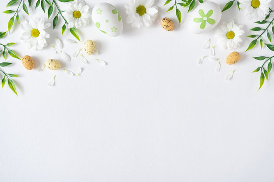 Creative layout made with colorful flowers and Easter eggs. Minimal nature background. Spring holidays concept.