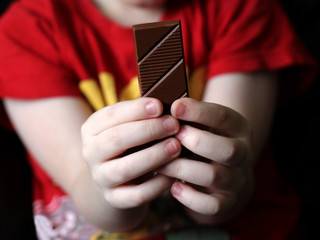Children's hands hold chocolate