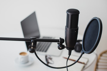 Microphone, earphones and laptop on table. Podcast
