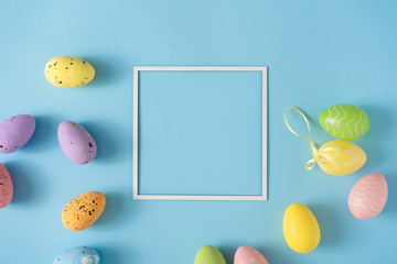 Easter layout made with colorful Easter eggs and pastel blue background. Minimal nature background. Spring holidays concept. Creative copy space. Flat lay.