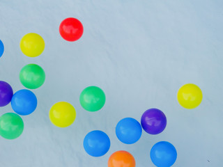 Many colored rubber balls float on the water.