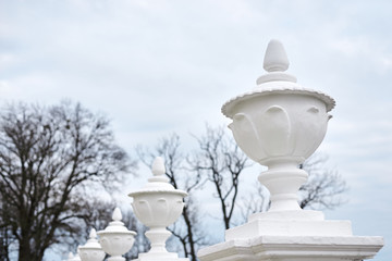 Naklejka premium White concrete fence with curved pillars in old historical park of ancient castle. Architectural background.