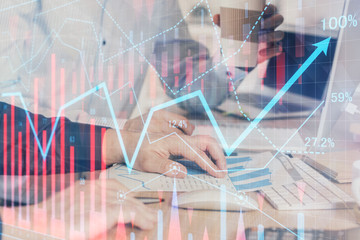 Multi exposure of chart with man typing on computer in office on background. Concept of hard work.