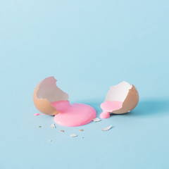 Skorupa jajka z pastelową różową farbą. Kreatywnie kopii przestrzeń na błękitnym tle. Minimalna koncepcja świąt wielkanocnych. - 332905940