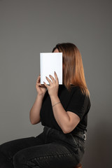 Happy world book and copyright day, read to become someone else - woman covering face with book...