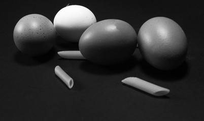 quattro uova e tre chicchi di pasta in bianco e nero