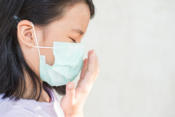 asia women wearing hygienic mask to prevent the virus PM2.5, Coronavirus, (2019-nCoV) asian little girl feeling unwell and coughing as symptom for cold or pneumonia,bronchitis. healthcare concept.