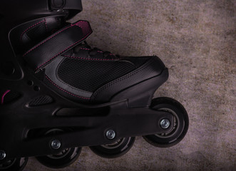  Detail of a black four-wheel inline skate for sports. Aerial view. Horizontal format.