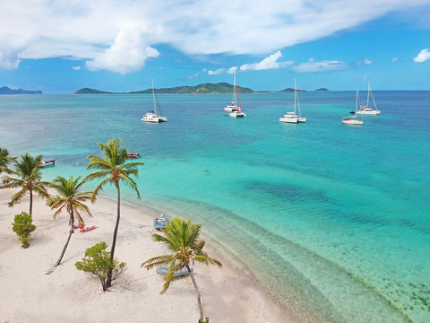Aerial view of Petit Rameau tropical Caribbean Island beach, sailing catamarans and boats 