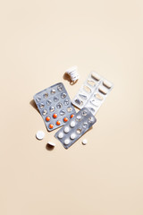 Different pills,tablets or capsules in blister on beige background top view flat lay.Concept of modern medical treatment,pharmacy,healthcare.Minimalistic abstract composition.Vertical orientation