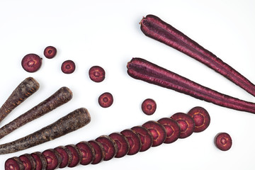 Fancy colorful vegetables. Set of purple carrots on light background. Copy space