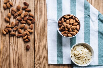 nuts in bowl on a wooden background. Rustic style. Almonds on a towel. Vegetarian food.
