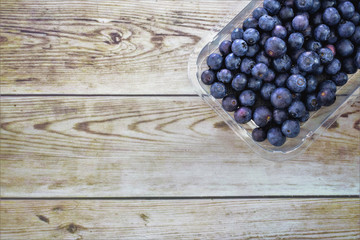 Tray with blueberries, wooden table background