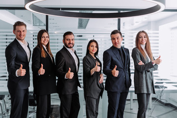 Fototapeta premium Group of thumbing up business people. Concept of teamwork and cooperation