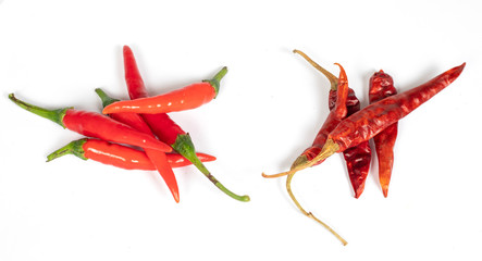 Fresh peppers and dried peppers on the same white background.