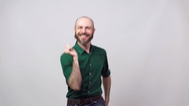 Happy bearded man dancing over white background. Concept of emotions.