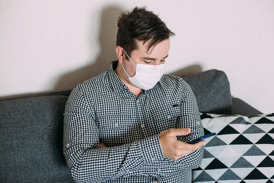 Man wearing mask working with smartphone working from home office