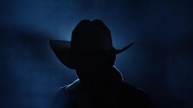 Portrait of a cowboy in the dark.