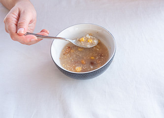 Traditional Turkish dessert ashure or Noah's Pudding with spoon on the table.