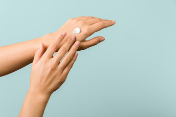 closeup view of woman hands applying hand cream. beauty shot