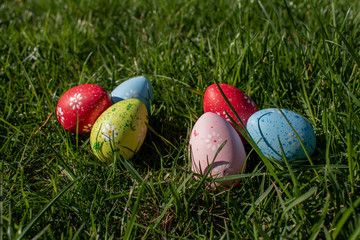 Colorful easter eggs on real grass background. Egg hunting