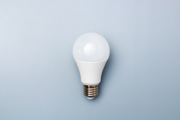 white led bulb against a grey background with copy space. energy efficiency concept