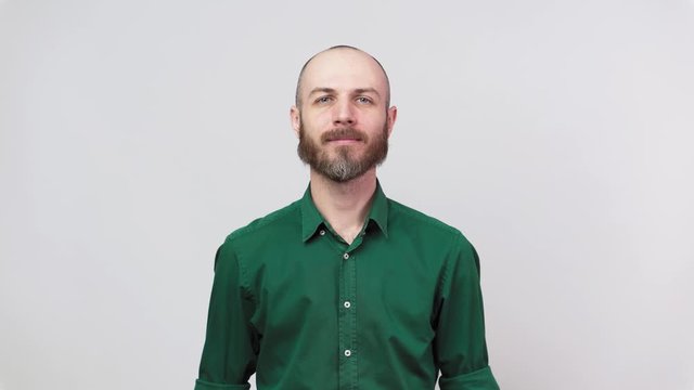 Portrait of calm bearded man looking at camera isolated over white background. Concept of emotions.