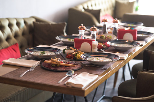 Brown Table Setting With First Courses And Snacks