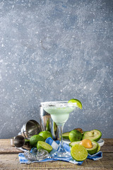 Alcoholic cocktail recipes and ideas. Avocado and lime margarita with salt, rustic wooden table copy table