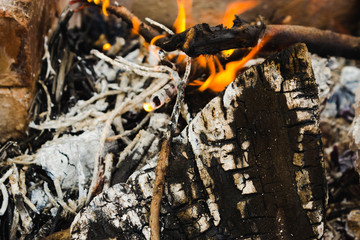 Burning wood (fire, coals and smoke). Lighting a fire from wooden logs and branches in a homemade barbecue made of bricks for cooking barbecue close up