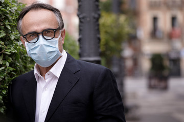 Ritratto di manager di mezza eta con una mascherina protettiva per evitare il contagio,...
