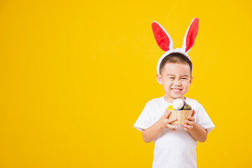 little children boy smile standing so happy bunny ears in Easter festival day holding easter eggs