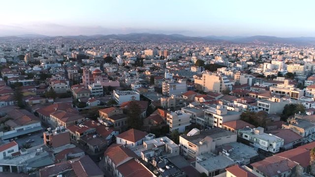 Limassol city at sunset, cityscape with horizon line, dawn, beautiful light, golden hour. Aerial footage