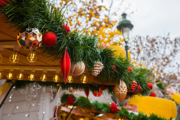 Christmas ornaments on a food stand. Christmas Market, Paris (Tuileries Gardens), France. Beautiful decorated wooden stand during the December winter holidays.  Blurred background.