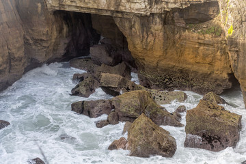 cliffs and froth at narrow inlet of Tasman sea shore, Punakaiki, West Coast, New Zealand