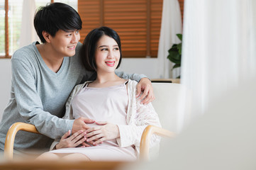 Asian man are hold his wife shoulder, she is pregnant and will have a baby. Couple life, Motherhood, family and kids relationship, new born baby, healthy pregnancy concept.