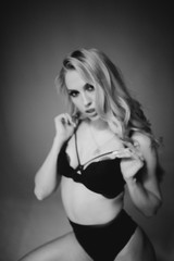 Fototapeta premium Blurred monochrome studio side portrait of young woman in black lingerie. Blur photo