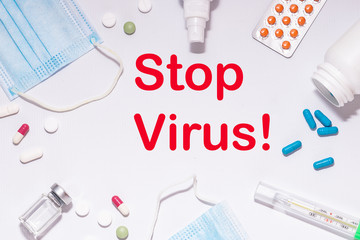 Stop Virus! banner with tablets, pills, sterile masks, antiseptic spray on white background. Flat lay overhead composition.
