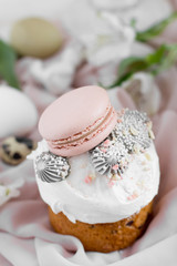 Easter cake kulich. selective focus Traditional easter sweet bread decorated with meringues and macaroons on a plate on a background of a vase with white tulips. Copy space