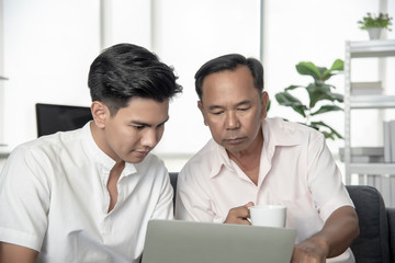 Senior Asian father and an adult son are talking to each other to buy life insurance after a nursing home. Family lifestyle. Concept of conducting disease prevention business.