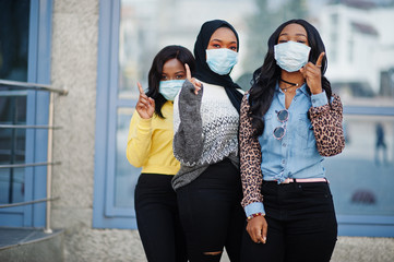 Group of three african american young volunteers wearing face mask outdoors. Coronavirus quarantine...