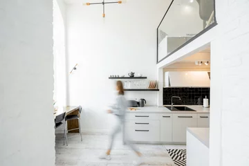 Foto op Plexiglas Binnenaanzicht van de lichte en moderne keuken met een wazig bewegend menselijk figuur © rh2010