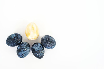 The concept of celebrating Easter. Colored cosmic dark blue with white dots and golden painted eggs on white background. Copy space. Isolated