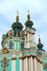 Fototapeta na wymiar Detailed view of medieval Saint Andrew Church against blue sky at sunny spring morning. Baroque style in ancient architecture. Christian orthodox cathedral. Kyiv, Ukraine